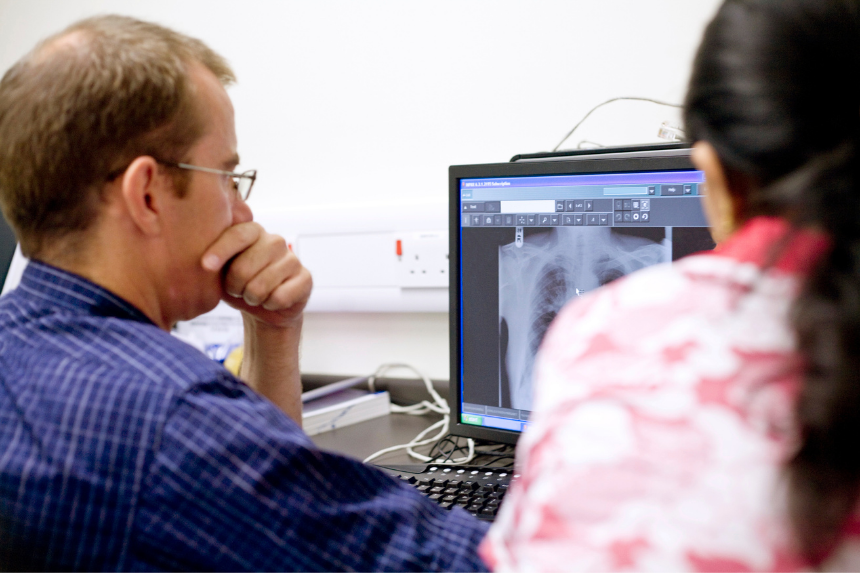 Clinicians looking at an x-ray on a screen