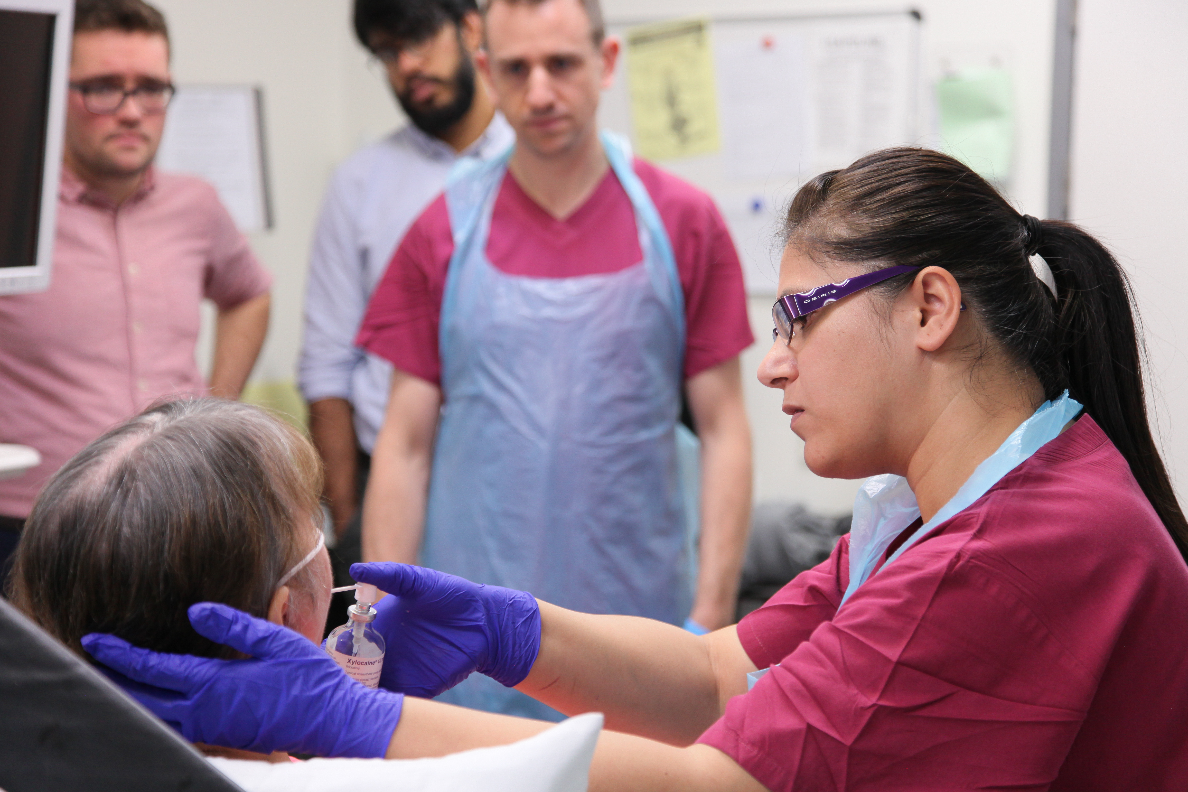 Clinician holding a bronchoscopy instrument to a patient’s mouth during a respiratory procedure